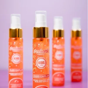 Botellas Minte Kids óleo capilar naranja con tapa dorada en fondo rosa