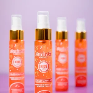 Botellas naranjas de aceite capilar Minte para niños con tapa dorada sobre fondo morado