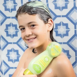 Niño con cabello enjabonado sosteniendo tratamiento Minte Kids hidratante