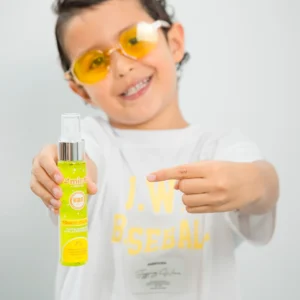 Niño con gafas amarillas señalando tónico capilar Minte Kids fortalecedor y protector
