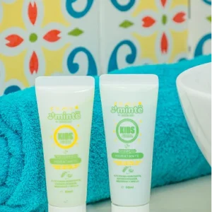 Tubos pequeños Minte Kids hidratante shampoo y tratamiento junto a toalla azul